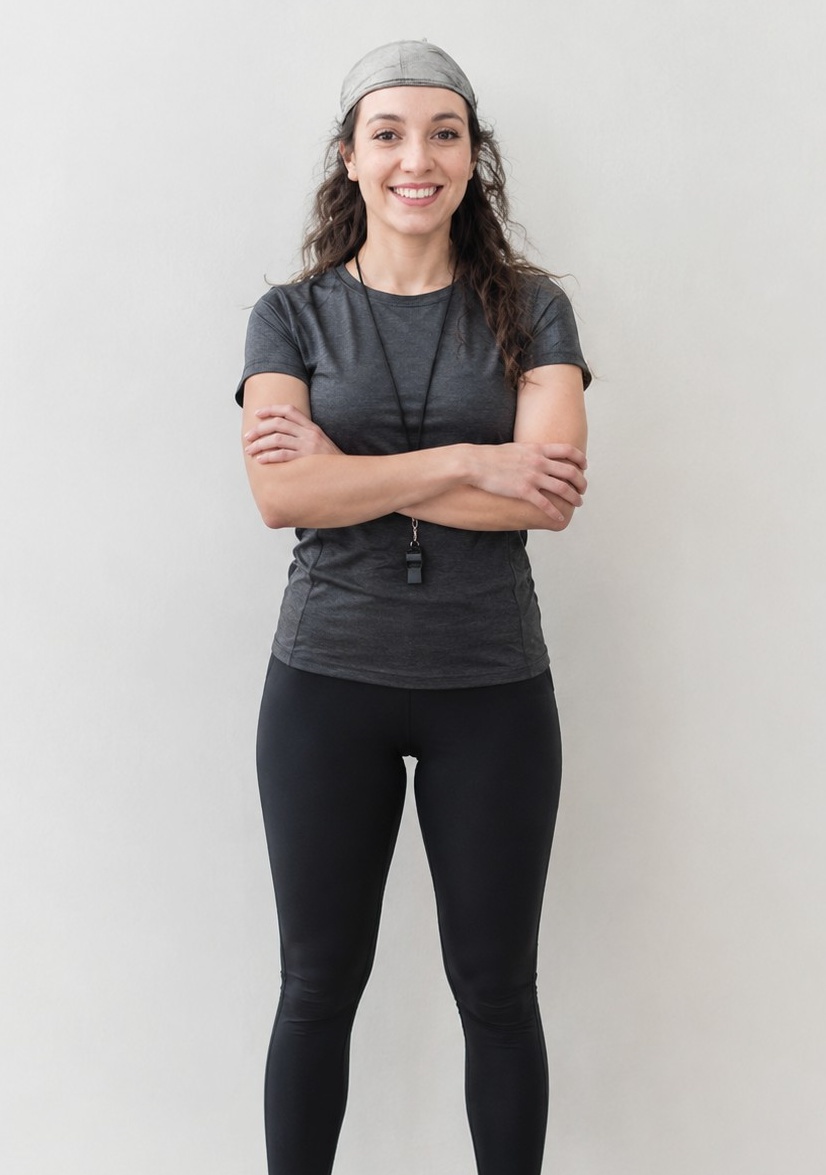 Sarah, coach sportive, debout face à l’objectif sur fond clair